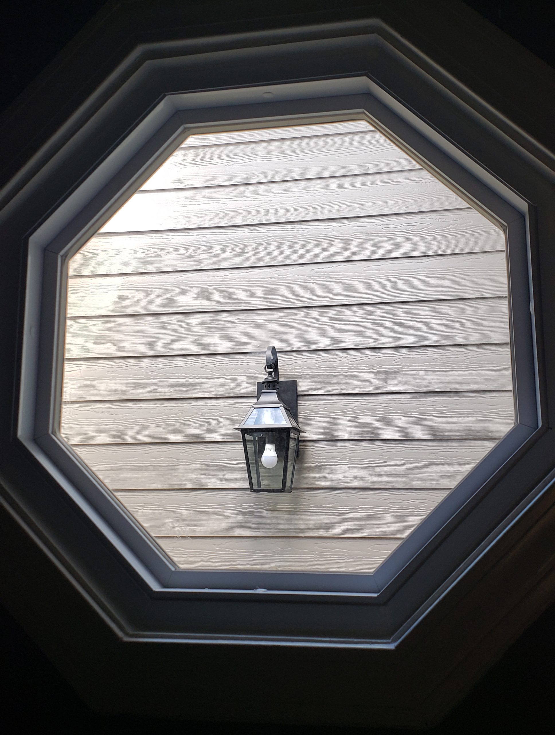 After: A fresh new outdoor light as seen through an octagonal window. - Lighting Makeover: Our Lights in a Real Home (My Home!) - LightsOnline.com Blog